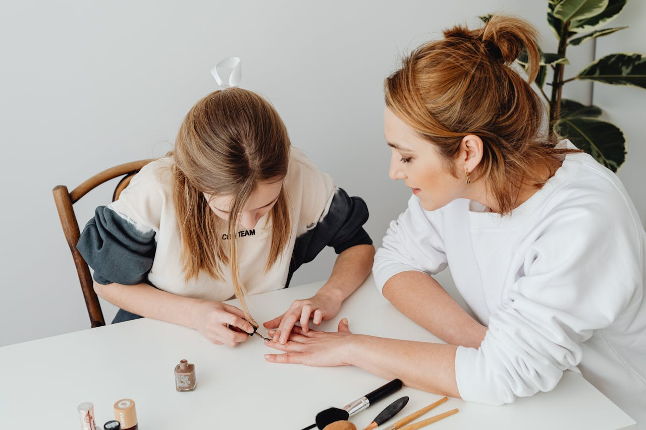 A mother and daughter bonding over a relaxing nail care session at home.